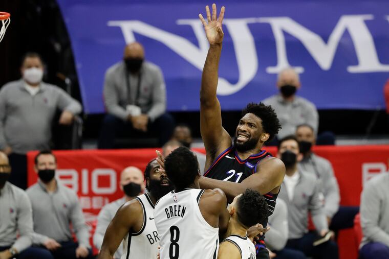 Sixers center Joel Embiid shoots the basketball over Brooklyn Nets guard James Harden, forward Jeff Green and guard Landry Shamet on Saturday, February 6, 2021 in Philadelphia.