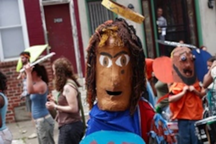 wears a puppet of himself and his mother (ME on one side, MOM on the other) at a 2007 parade.