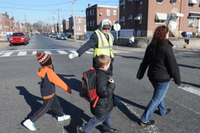 Elizabeth Biddle, 53, helps about 500 kids a day cross the street at Cottage Street and Bleigh Avenue, in Holmesburg. Biddle, who's done the job since 1980, is one of the city's longest-service crossing guards. (Sarah J. Glover / Staff Photographer)