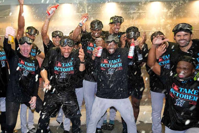 The Marlins celebrate in the locker room after clinching a playoff berth with a win over the Pirates on Saturday.