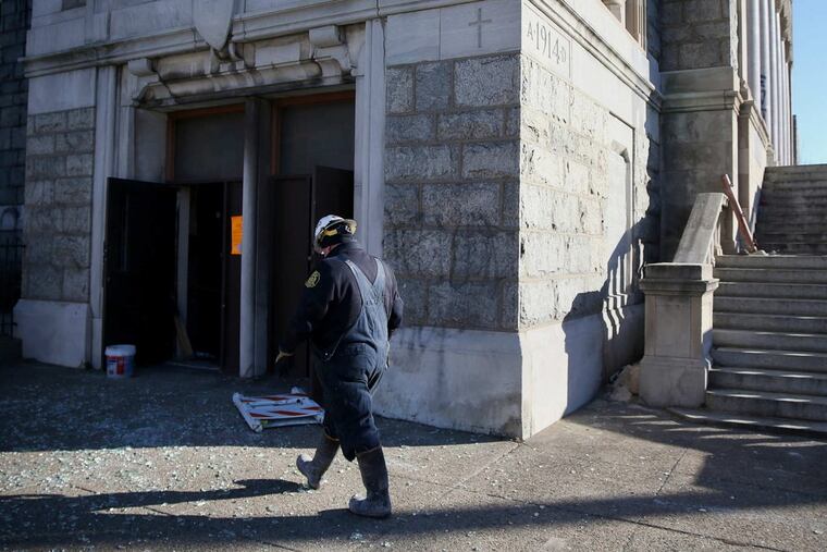 Philadelphia fire investigator walks across broken glass after a two-alarm fire overnight at the abandoned Ascension of Our Lord Church in Philadelphia on Thursday, Dec. 28, 2017.