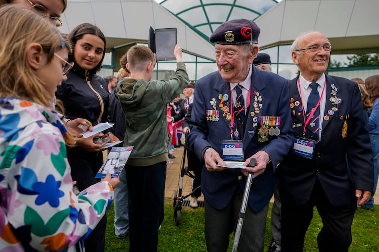 British World War II veteran John King is greeted by a young girl prior to a service at the Pegasus Bridge memorial in Benouville, France, Normandy, on Wednesday. World War II veterans from across the United States as well as Britain and Canada are in Normandy this week to mark 80 years since the D-Day landings that helped lead to Hitler's defeat.