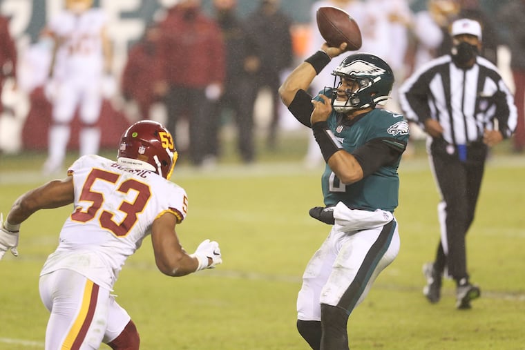 Eagles quarterback Jalen Hurts throws the football during the third quarter while pressured by Washington inside linebacker Jon Bostic.