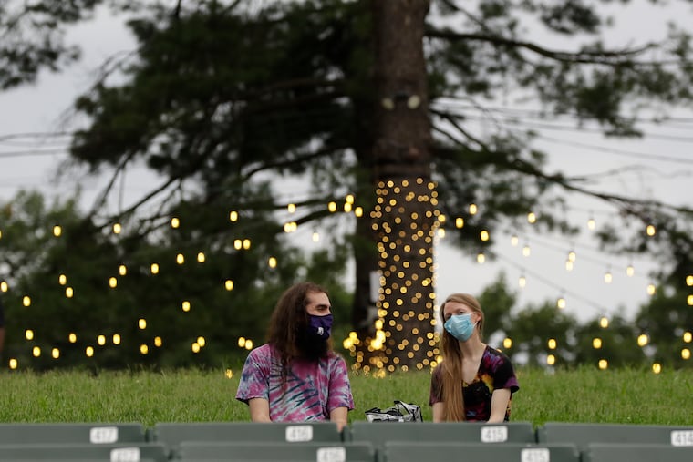 Masked fans sit outside at the Mann Center in late August, awaiting a concert by Wilco, Sleater-Kinney and Nnamdï.