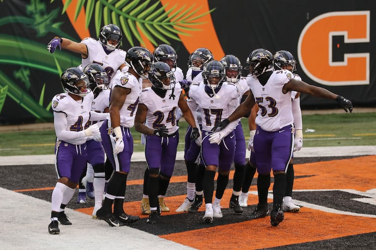 The Ravens defense celebrates with cornerback Marcus Peters (24) after he intercepted a pass in the end zone against the Bengals on Sunday.