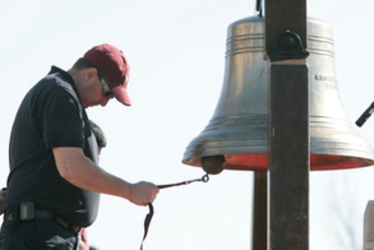 A Virginia Tech employee rings a bell in memory of the dead. The bell was rung 33 times - once for each person who died in the April 16 shootings.