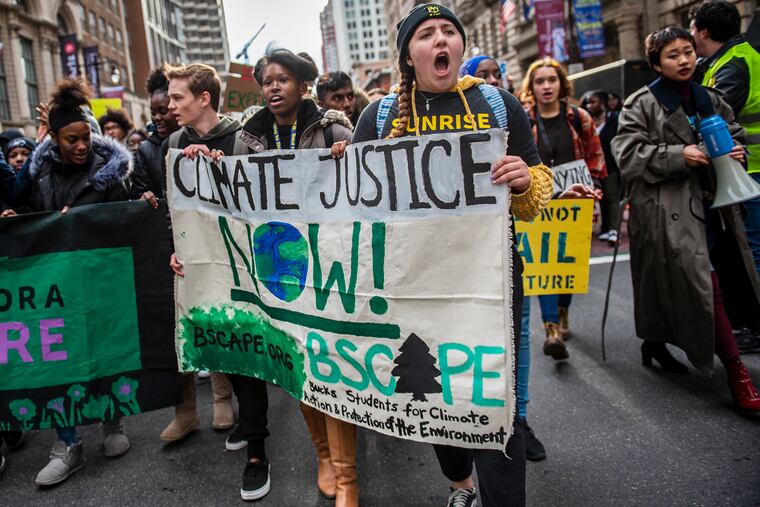 People march at the Youth Climate Change Strike at City Hall on Friday.