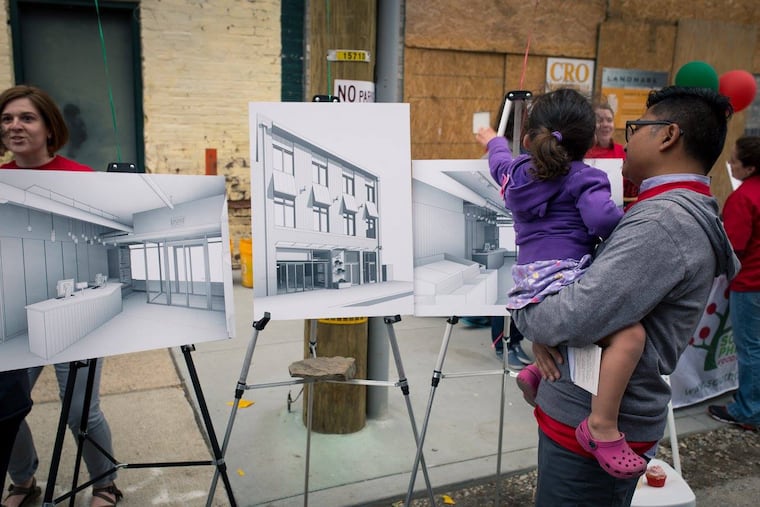 A man and his daughter look at building plans for the new South Philly Food Co-op, where'll be a member-owner.