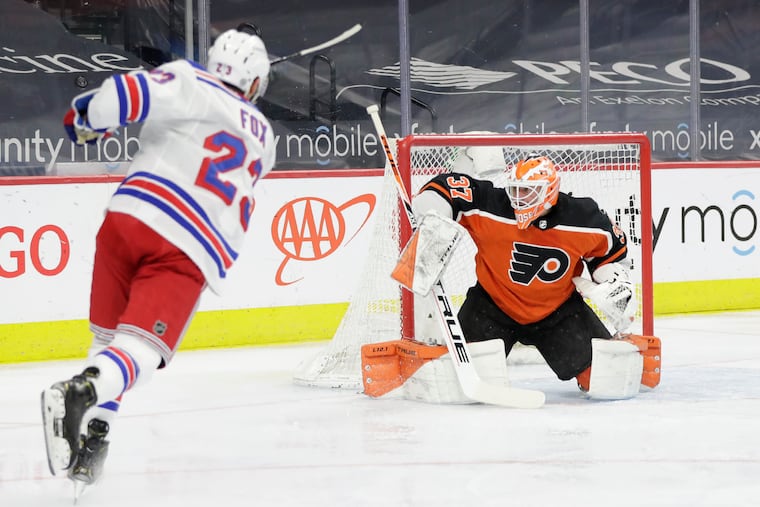 Flyers goaltender Brian Elliott defends as Rangers defenseman Adam Fox uncorks a shot on March 27. The Flyers won, 2-1, on Samuel Morin's first NHL goal.