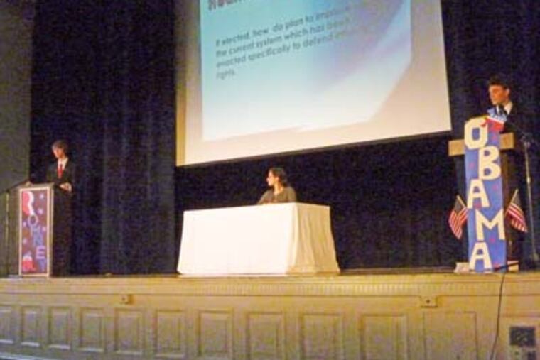 Hannah Kearney moderates the debate between classmates Tim Green (left) and Max Holm. JOSEPH TRINACRIA / Staff
