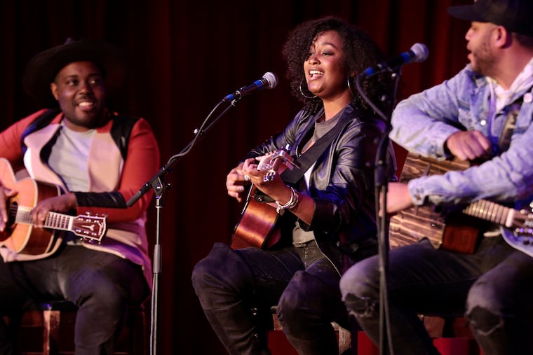 The Black Opry Revue (left-right) Jett Holden (left) and Tylar Bryant (right) look on as Roberta Lea performs at City Winery Philadelphia in Phila., Pa., on Feb. 16, 2022. The Black Opry Revue is a touring group of Black country, folk and blues singers who are calling attention to the often-erased history of Black performers in country music.