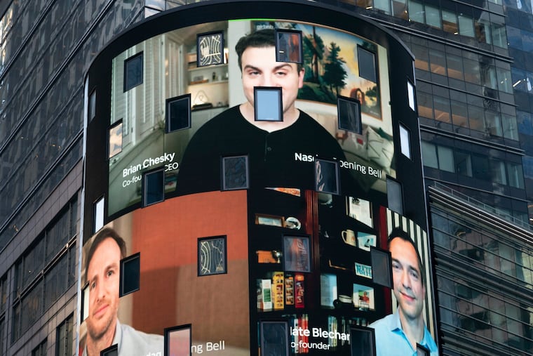 The electronic screen at the Nasdaq MarketPlace in New York displays the Airbnb co-founders Brian Chesky (top), Joe Gebbia (left), and Nathan Blecharczyk. The San Francisco-based online vacation rental company had its IPO Thursday.