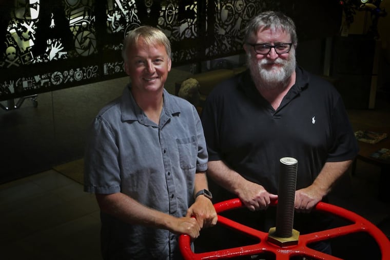 Erik Johnson (left) and Gabe Newell, founder/CEO and longtime executives at Valve Corp. stand near a stem valve that came from a submarine in the lobby of Valve's headquarters in Bellevue, Wash. The valve was a gift from Gabe's brother Dan who found it in a scrapyard in Kirkland, Wash.
