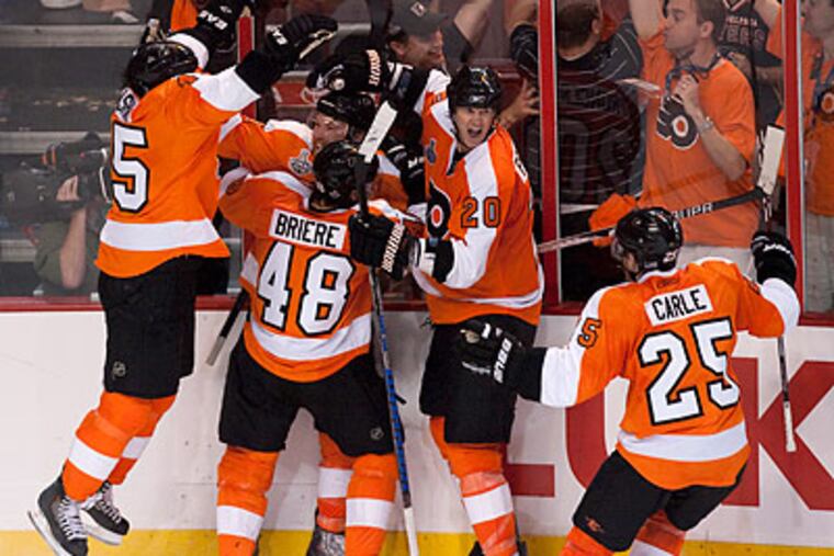 Flyers players celebrate Claude Giroux's game-winning goal in overtime. (Ed Hille/Staff Photographer)