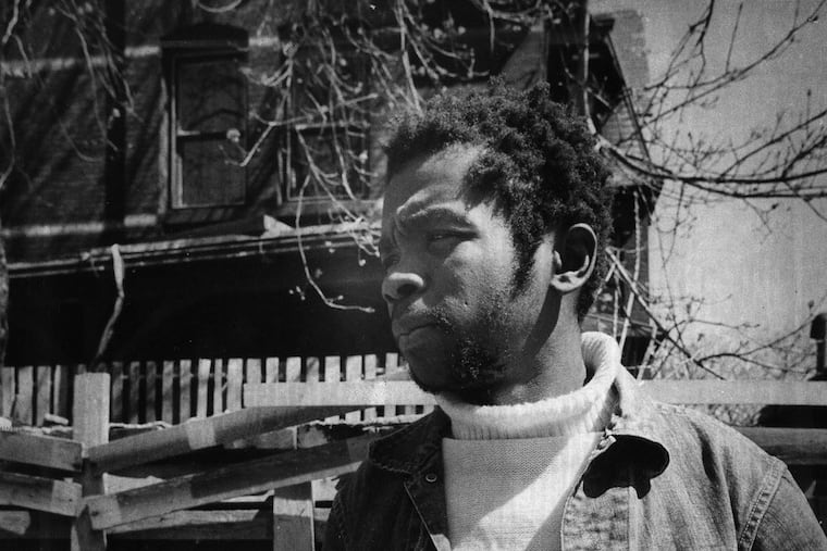 Baewolf Africa holds bloody broken police nightstick and police hat left by police after a confrontation. MOVE members claimed that the baby of Janine Africa was killed by police.