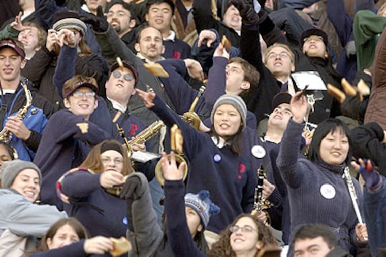 Members of the University of Pennsylvania band take part in the ritual of toast throwing during a Penn/Brown football game in 2002. Given growing poverty and hunger rates, it may be time to rethink that tradition. (Charles Fox / Staff Photographer)