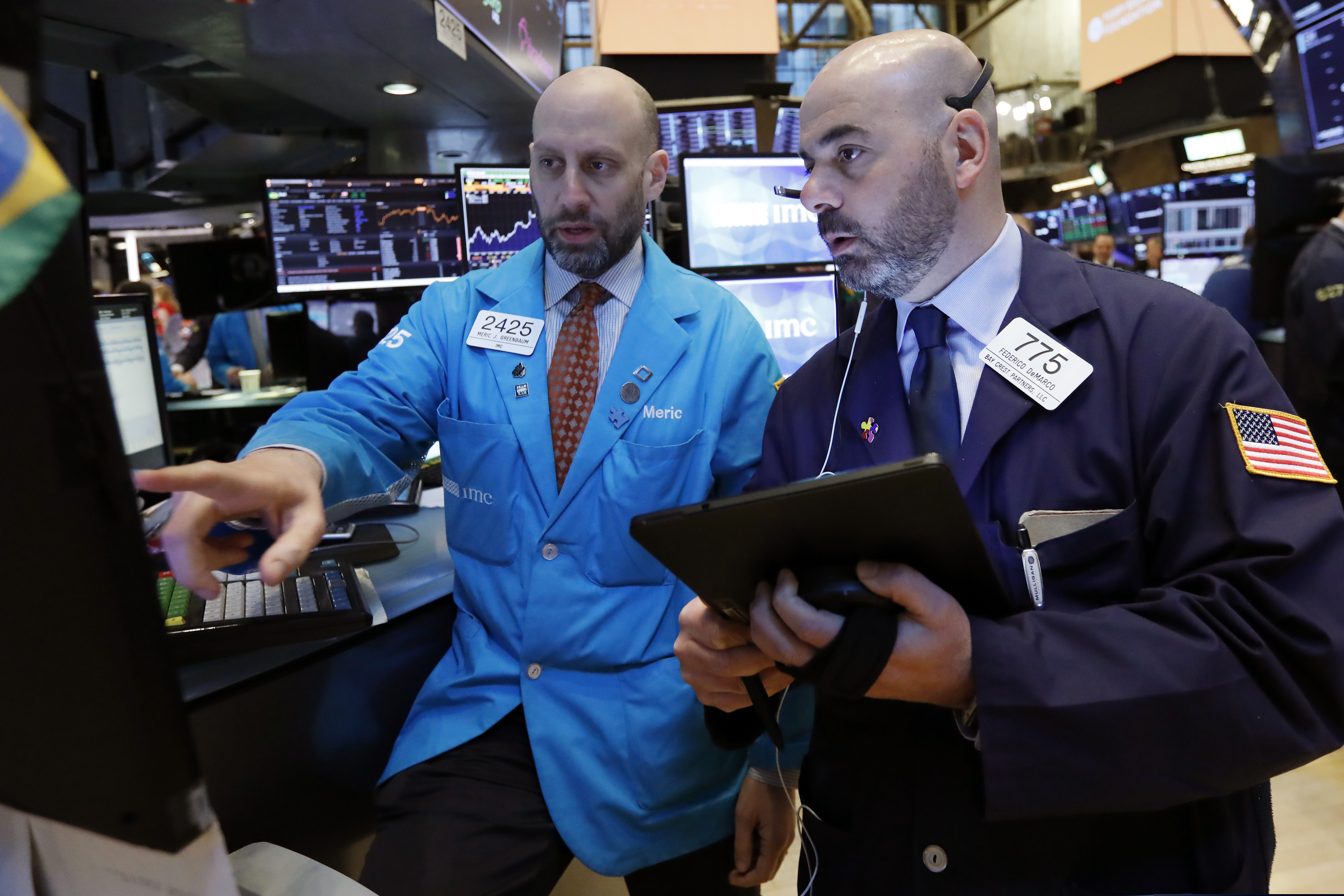 Specialist Meric Greenbaum, left, and trader Fred DeMarco work on the floor of the New York Stock Exchange.