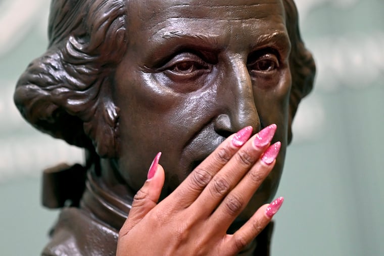 Akosua “Kosi” Asabere examines the statue of George Washington of Virginia as the National Constitution Center launches a new series of tactile touch tours for blind and low-vision visitors Sunday, April 19, 2026. They had Signers' Hall entirely to themselves before the center opened.