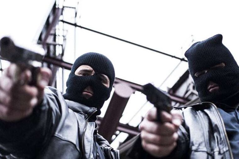 In a reenactment, mob members played by actors Michael Wren and Ray Schwartz take aim at a hit victim.