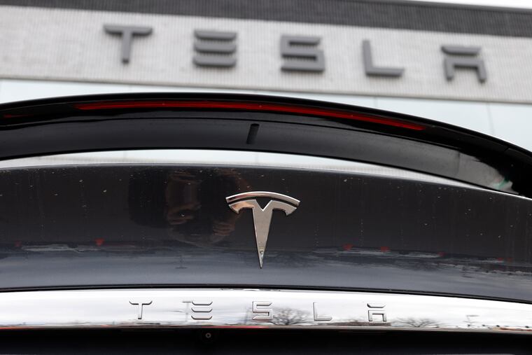 The Tesla company logo shines off the rear deck of an unsold 2020 Model X at a Tesla dealership in 2020 in Littleton, Colo.