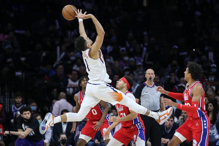 Sixers Matisse Thybulle, right, fouls Suns Devin Booker during the 3rd quarter at the Wells Fargo Center in Philadelphia, Tuesday, February 8, 2022.