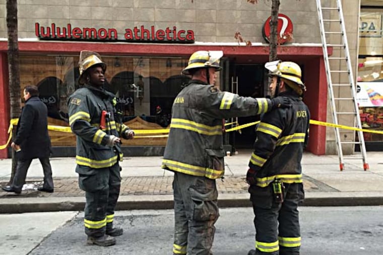 Firefighters gather in front of lululemon athletica store on the 1500 block of Walnut Street in Philadelphia. Bricks from an adjoining building fell on January 27, 2015. ( DAVE MAIALETTI / Staff Photographer )