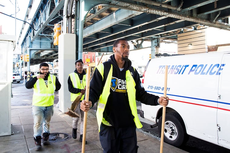 Volunteers with PowerCorps, a division of AmeriCorps, return brooms used in their cleanup to a station set up underneath the Somerset stop on the Market Frankford subway line. PowerCorps was one of several organizations to aid in the Kensington neighborhood cleanup on November 1. RACHEL WISNIEWSKI / For the Inquirer