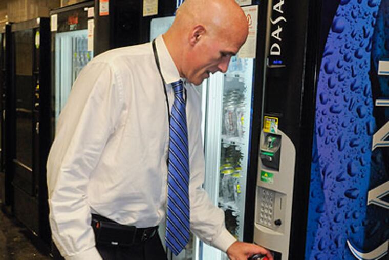 Ed Fischer buys a can of Coke down the hall from his office in City Hall. (Ron Tarver / Staff Photographer)