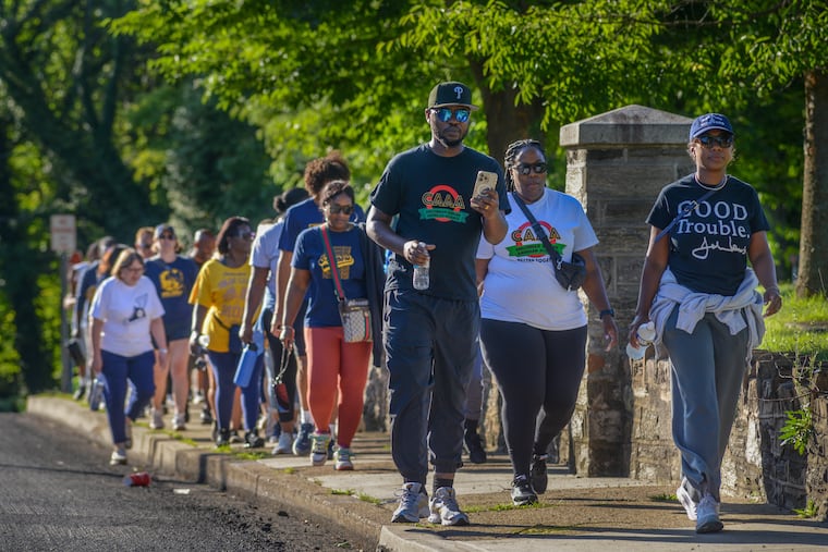 Maurice Freeman (third from right), Rose-Anne Matthews (second from right) and Takiyah Burns (right), all board members of Cheltenham African American Alliance, lead the way during a community march before the new school year begins Saturday, Aug. 30, 2026, on Ashbourne Road near the Cheltenham School District Administration Building in Elkins Park. Dr. Brian Scriven resigned as superintendent of the Cheltenham School District in the aftermath of Cheltenham High School football coaches and players being charged with assault in a locker room hazing incident. Dr. Chris McGinley recently took over as interim superintendent.