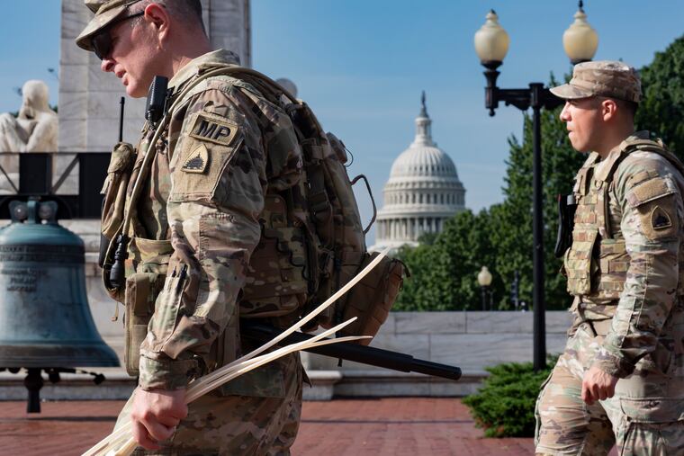 National Guard personnel keep watch as travelers arrive at the entrance to Union Station near the Capitol in Washington on Thursday, Aug. 14, 2025.