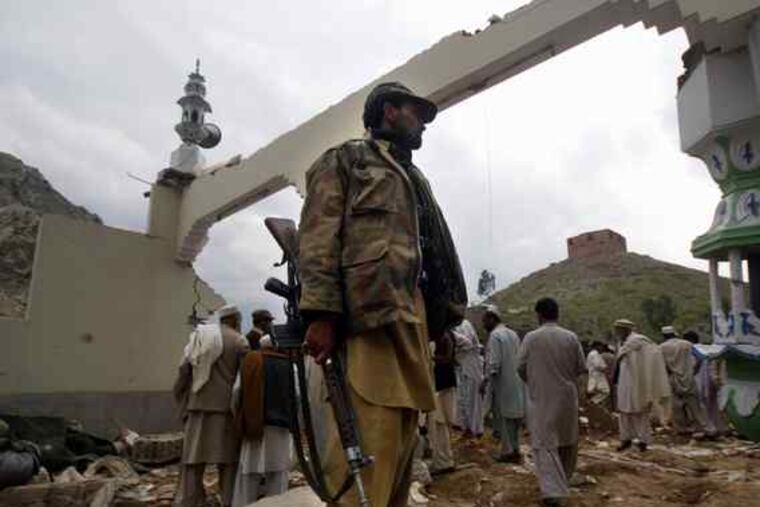 The mosque's ruins frame a security officer after the blast. The bomber struck as worshipers packed the mosque.