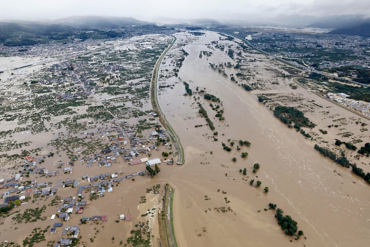 A residential area is submerged in muddy waters after an embankment of the Chikuma River broke because of Typhoon Hagibis, in Nagano, central Japan, Sunday, Oct. 13, 2019.