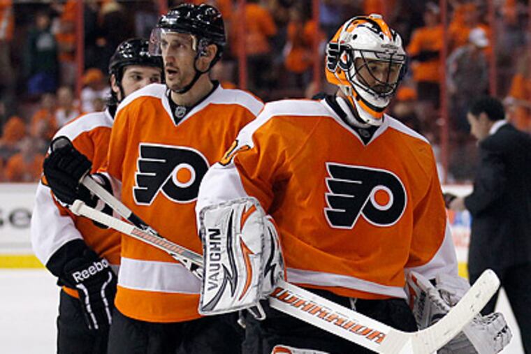 Brian Boucher and Blair Betts walk off the ice after the Flyers lost Game 2 to the Flyers in overtime. (Yong Kim/Staff Photographer)
