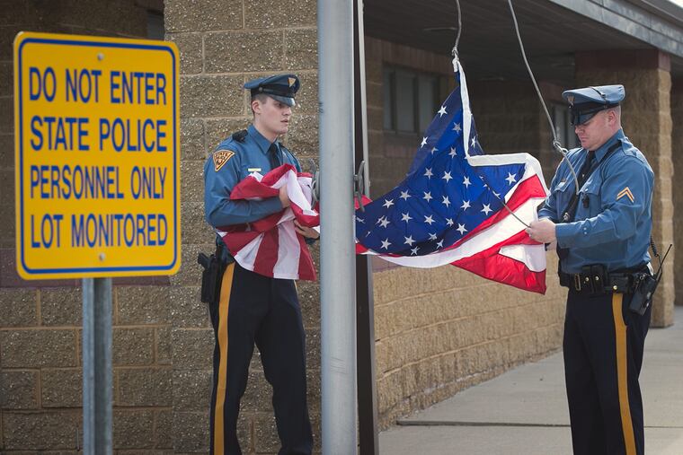New Jersey state troopers prepare to fly a new U.S. flag outside the Bellmawr barracks, where Trooper Sean Cullen had been stationed.
