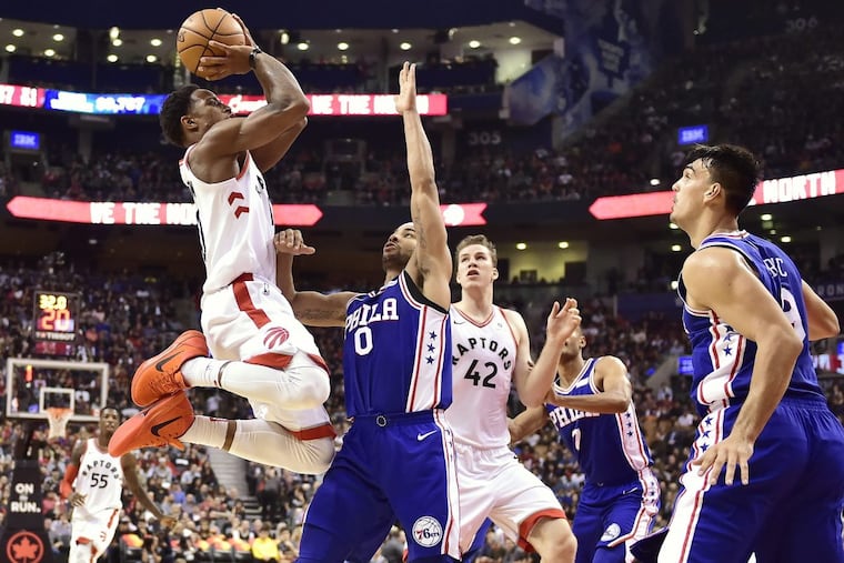 Raptors guard DeMar DeRozan (left) shoots over 76ers guard Jerryd Bayless (0) as Raptors center Jakob Poeltl (42) and 76ers forward Dario Saric (right) look on.