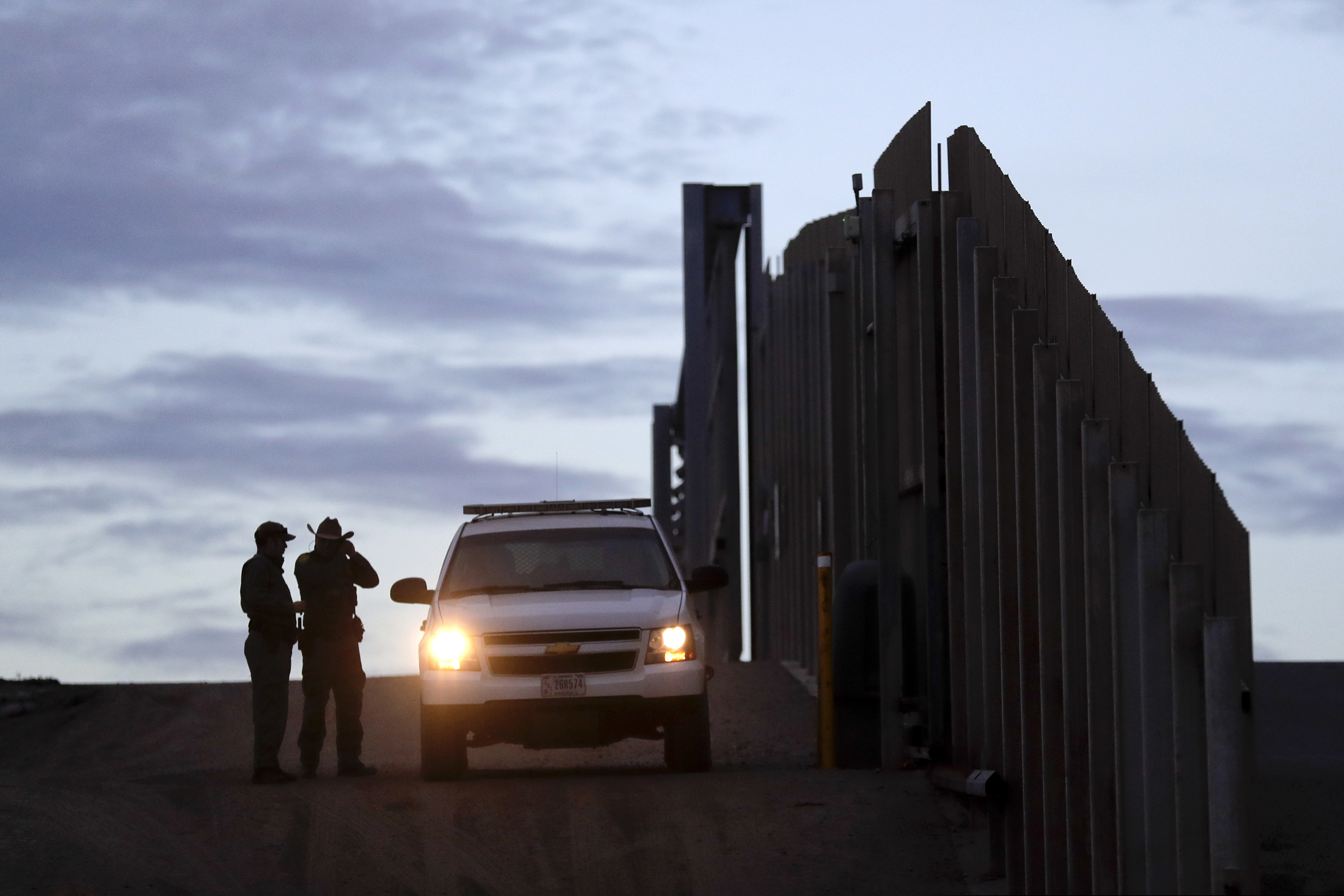 In this Nov. 21, 2018 photo, United States Border Patrol agents stand by a vehicle near one of the border walls separating Tijuana, Mexico and San Diego, in San Diego. As of this week, the ACLU has filed nearly 400 lawsuits and other legal actions against the Trump administration, some meeting with setbacks but many resulting in important victories. Of the lawsuits, 174 have dealt with immigrant rights.