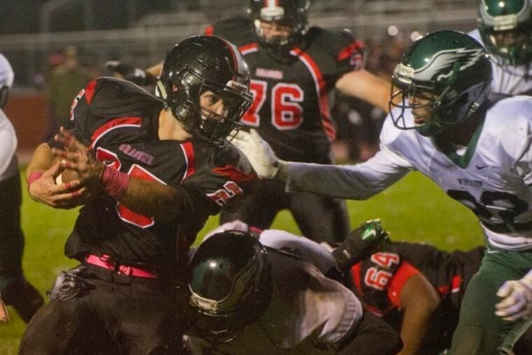 Kingsway's Anthony Seas (center, 25) runs the ball as Winslow Township's Khan Clark (right, 22) tries to make the tackle during Friday night's game at Kingsway High School in Woolwich, NJ.