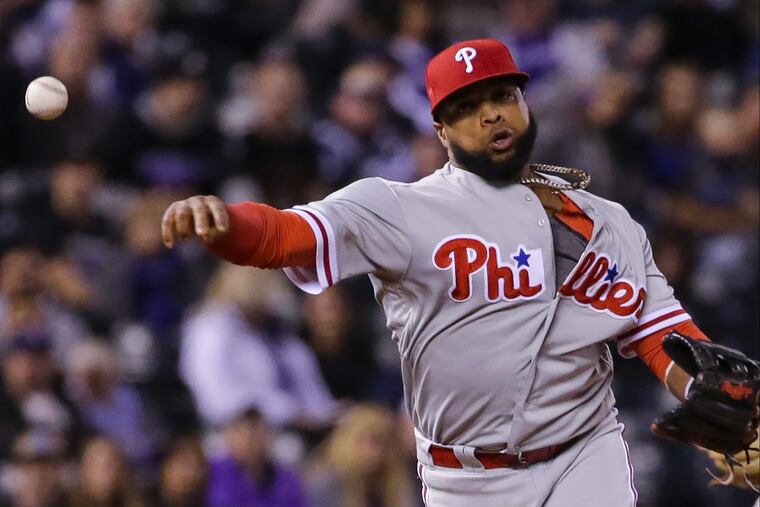 Phillies third baseman Carlos Santana (41) throws to first to retire a Rockies batter Tuesday night.