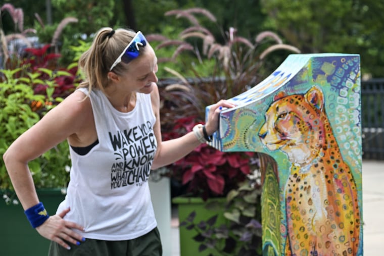 Christina Barnabic stands with a statue at the Philadelphia Zoo Saturday, Aug. 8, 2026.