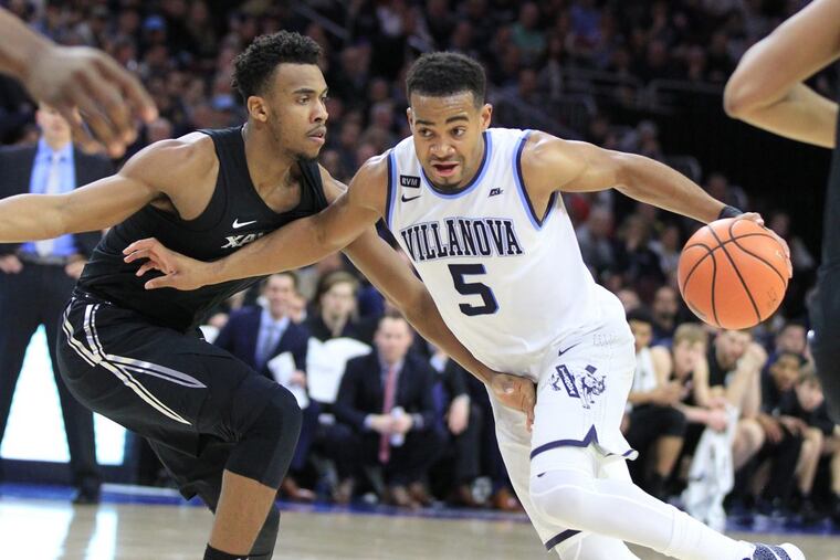 Phil Booth, right, driving against Paul Scruggs of Xavier earlier this month, will be sidelined indefinitely.
