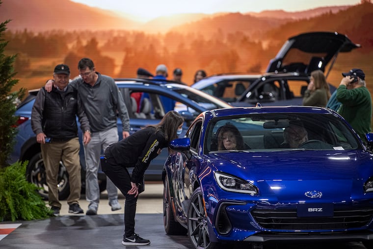 People walk along the Subaru showroom at the 2022 Philly Auto Show in Philadelphia.