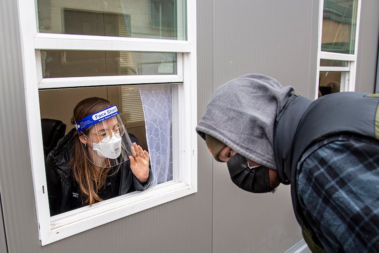 Jill Gansert administers a free COVID-19 rapid test inside a trailer on Wednesday at the Sayre Health Center COVID Testing Site (in schoolyard of Sayre High School) in Philadelphia High School.