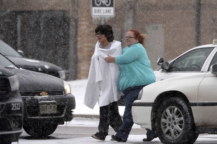 Amid reports of a shooter , a person is escorted to safety in Colorado Springs. Confusion lasted through the afternoon over whether the gunman was at large or holed up at the facility with staff and patients. ANDY CROSS / Denver Post via AP