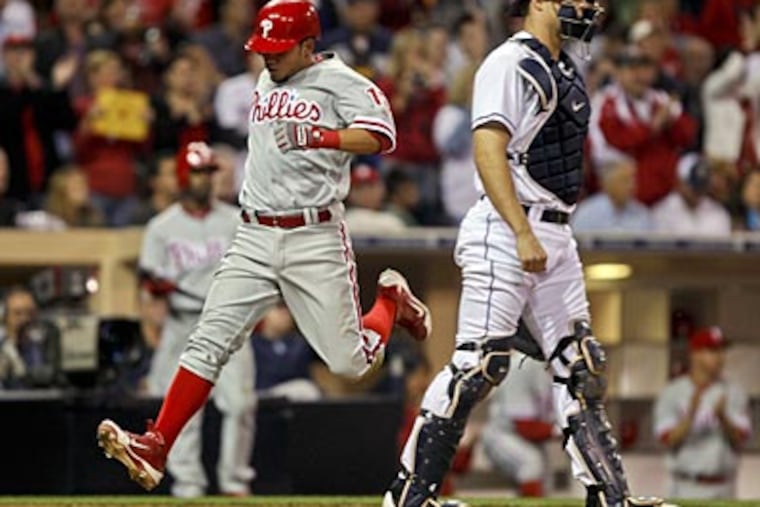 Freddy Galvis races past Padres catcher Nick Hundley to score in the seventh inning. (Lenny Ignelzi/AP)
