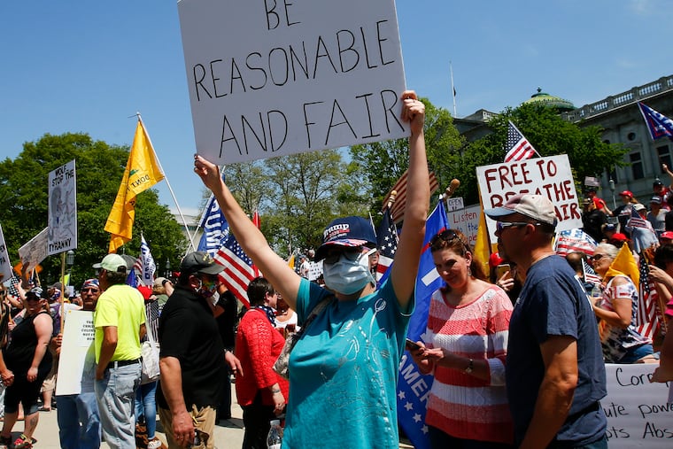A ReOpen PA demonstrator holds up a sign during a protest on the steps of the Pa. State Capital in Harrisburg last week.
