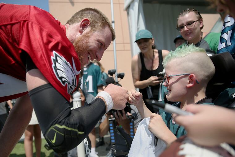 Philadelphia Eagles quarterback Carson Wentz, left, fist-bumps Giovanni Hamilton, 11, of Muncy, Pa., after Eagles training camp at the NovaCare Complex in South Philadelphia.