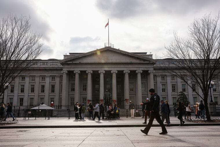 Pedestrians walk past the U.S. Department of the Treasury in Washington, D.C.