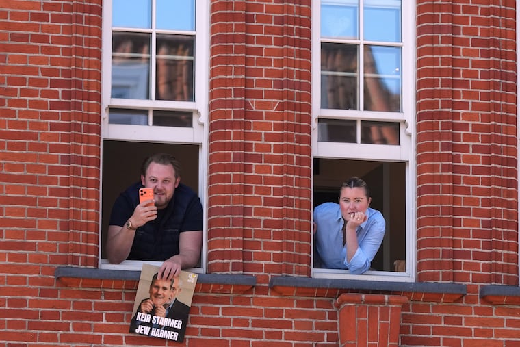 People look out of a window near the scene where two people were stabbed the previous day in the Golders Green neighbourhood, which has a large Jewish community, in London, Thursday, April 30, 2026.