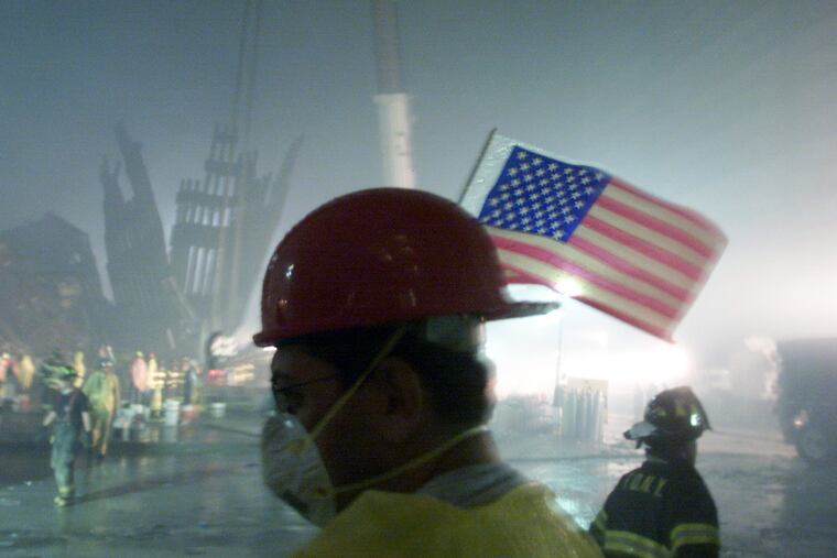 The facade of one of the towers of the World Trade Center lies in ruins as workmen work in the early morning hours on Sept. 14, 2001. (GARY FRIEDMAN/Los Angeles Times/TNS)