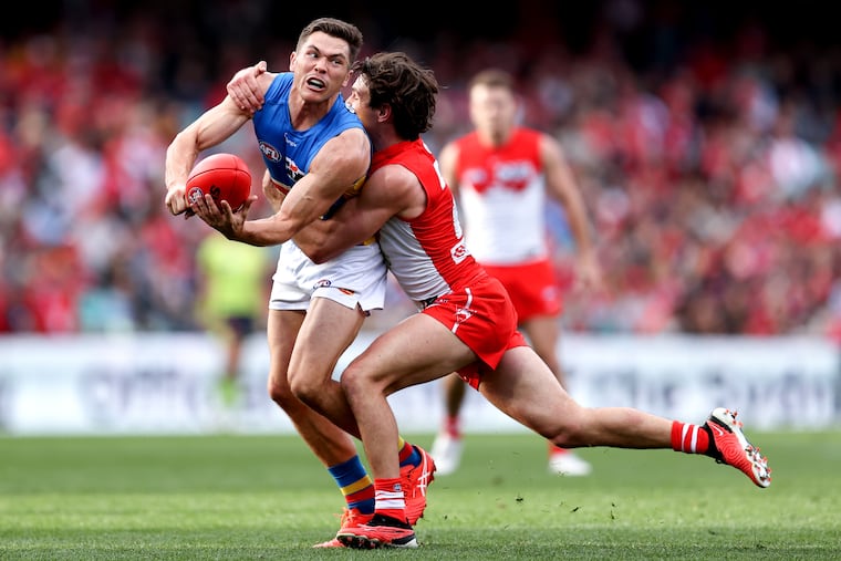 The Sydney Swans' Errol Gulden (right) tries to tackle the Gold Coast Suns' Ben Ainsworth during Saturday's game.